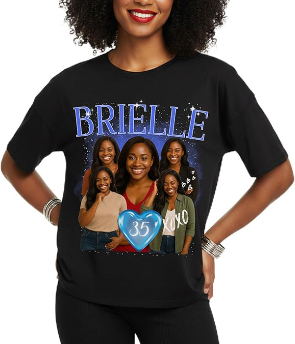 Person wearing a black t-shirt with a graphic design featuring the name 'BRIELLE' and images of women.